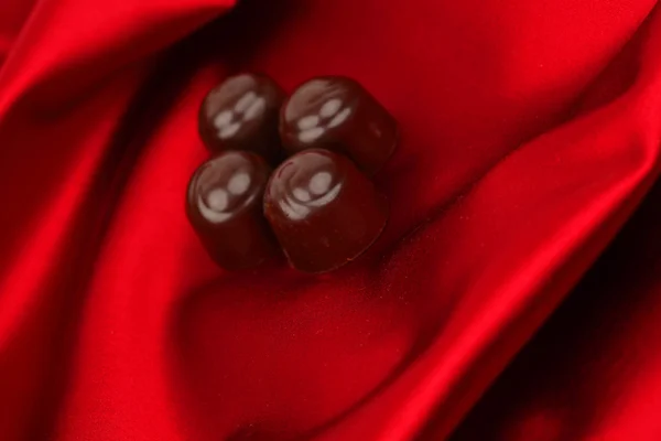 stock image Chocolate candy on red satin