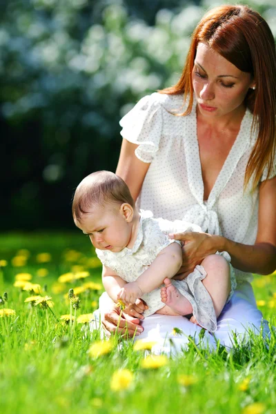 Moeder en dochter op het groene gras — Stockfoto