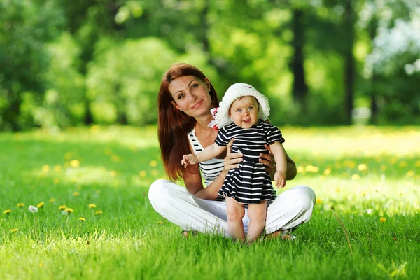 Mor och dotter på det gröna gräset — Stockfoto