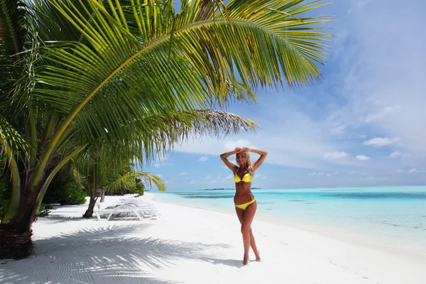 Kvinna i bikini under palm — Stockfoto