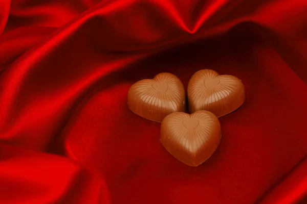 Corações doces em cetim vermelho — Fotografia de Stock