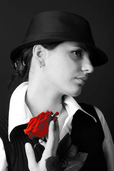 Дівчина в капелюсі тримає червону троянду — стокове фото