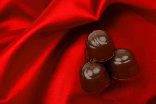 Stock image Chocolate candy on red satin