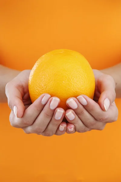 Πορτοκαλί στα χέρια γυναίκα — Φωτογραφία Αρχείου