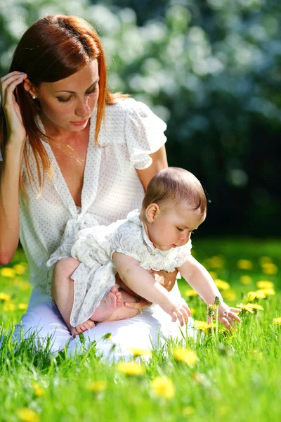 Madre e hija en la hierba verde —  Fotos de Stock