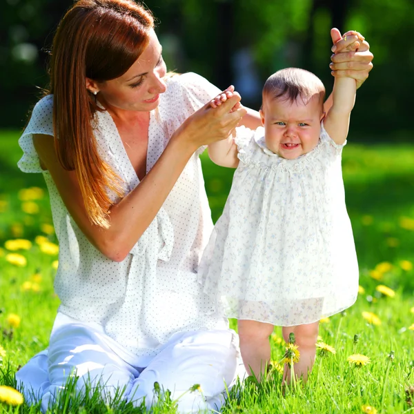 Anne ve kızı yeşil çimenlerin üzerinde — Stok fotoğraf