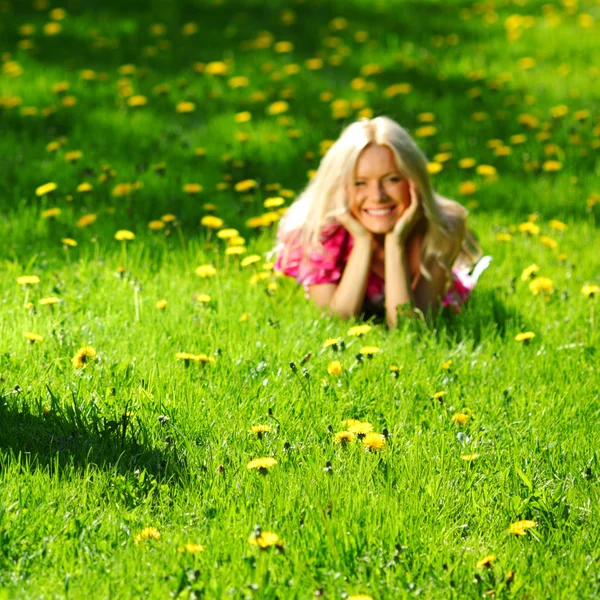 Girl on dandelion field — Stock Photo, Image