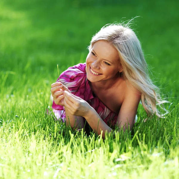 Blondine liegt auf grünem Gras — Stockfoto