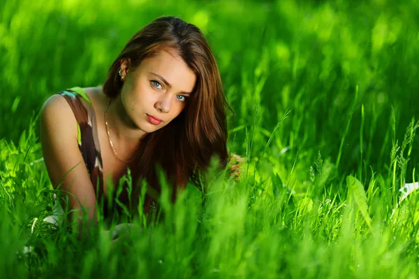 緑の芝生の上に横たわるブルネット — ストック写真