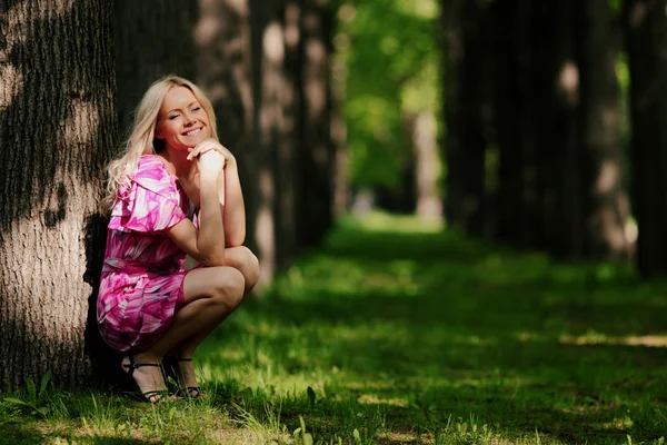 Kvinna på en skuggig park gränd — Stockfoto