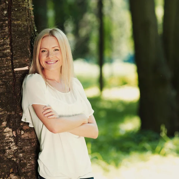 Meisje permanent naast een boom — Stockfoto