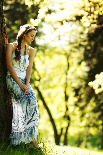 Chica de pie junto a un árbol — Foto de Stock
