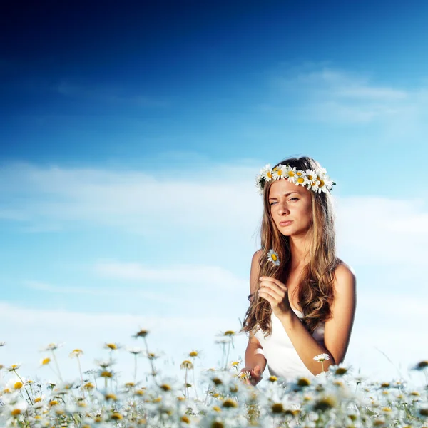 Mädchen im Kleid auf dem Gänseblümchenblumenfeld — Stockfoto