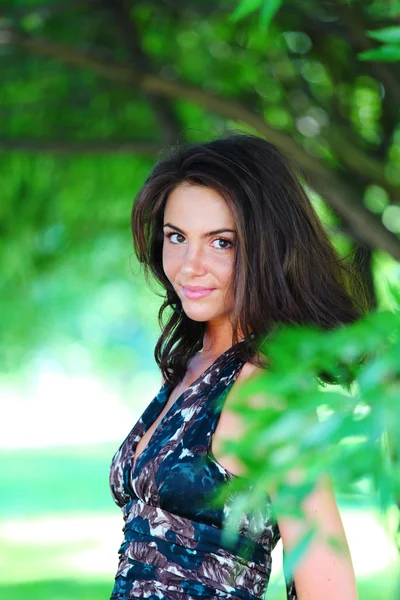 Girl on a background of green trees — Stock Photo, Image