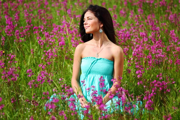 Mulher no campo de flores rosa — Fotografia de Stock