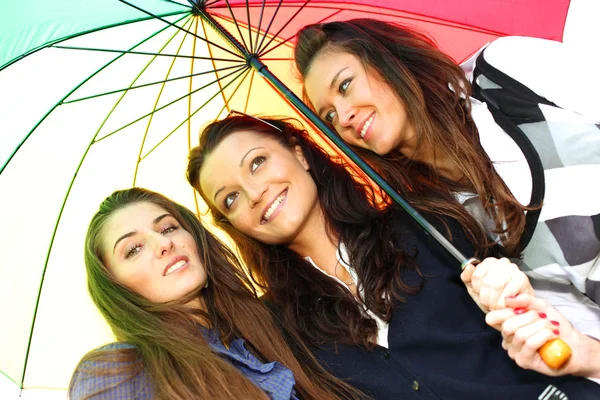 Улыбающиеся девушки под зонтиком — стоковое фото