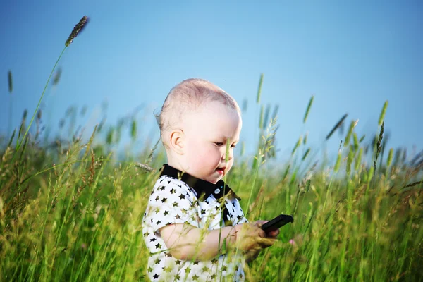 소년 잔디에 있는 전화로 전화 — 스톡 사진