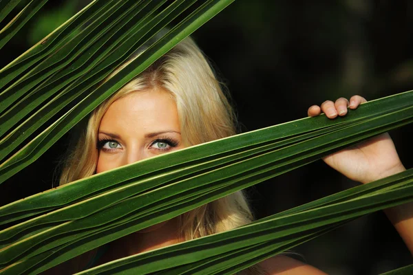 Mulher atrás das folhas da palma — Fotografia de Stock