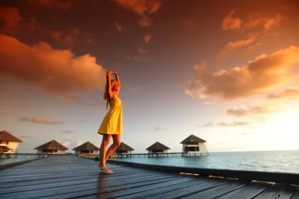 Femme en robe sur le coucher du soleil maldivien — Photo