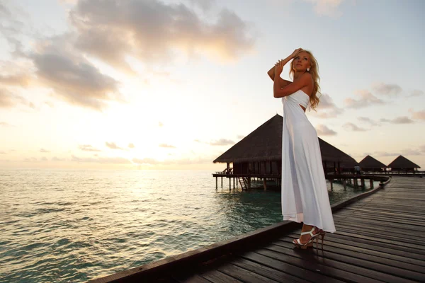 Женщина в платье на мальдивском закате — стоковое фото