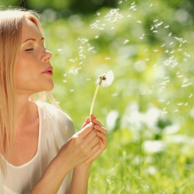 Girl blowing on a dandelion clipart