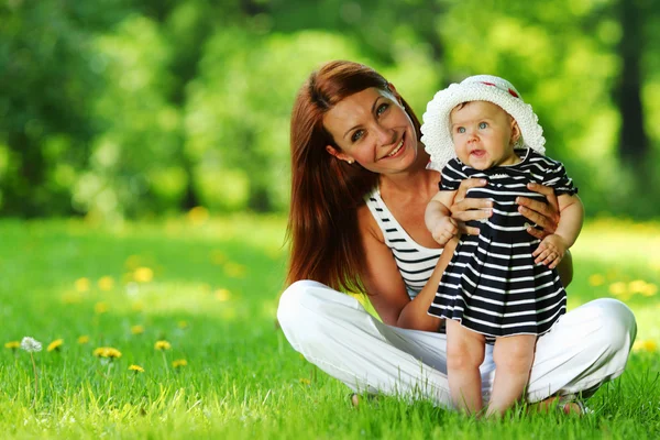 Mor och dotter på det gröna gräset — Stockfoto