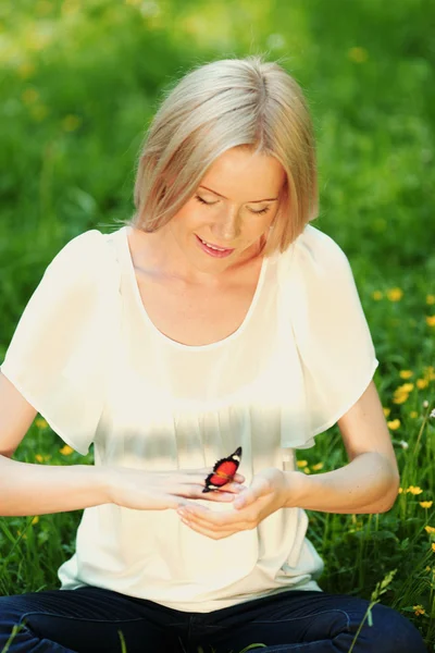 Woman playing with a butterfly — Stock Photo, Image