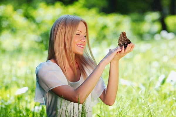 Bir kelebek ile oynayan kadın — Stok fotoğraf
