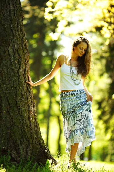 Girl standing next to a tree — Stock Photo, Image
