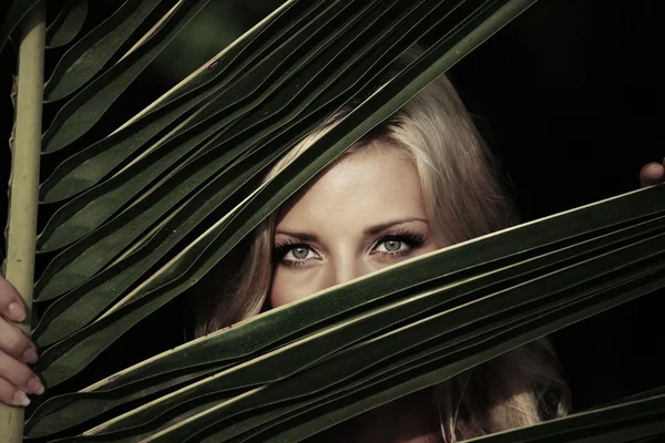 Mujer detrás de las hojas de la palma — Foto de Stock