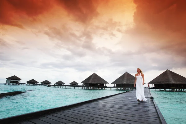 Mulher em um vestido no pôr do sol maldivo — Fotografia de Stock