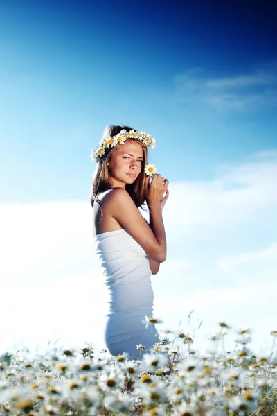 Mädchen im Kleid auf dem Gänseblümchenblumenfeld — Stockfoto