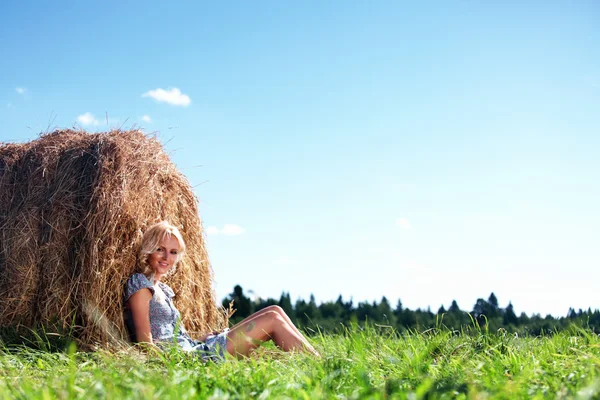Meisje naast een stapel van hooi — Stockfoto