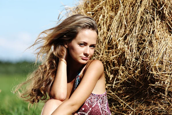Girl next to a stack of hay — Stock Photo, Image