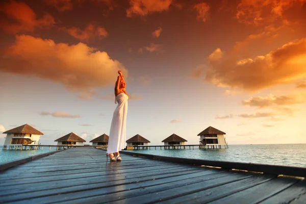 Kobieta w sukni na Malediwach zachód słońca — Zdjęcie stockowe