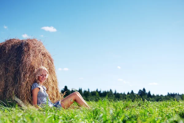 Mädchen neben einem Stapel Heu — Stockfoto