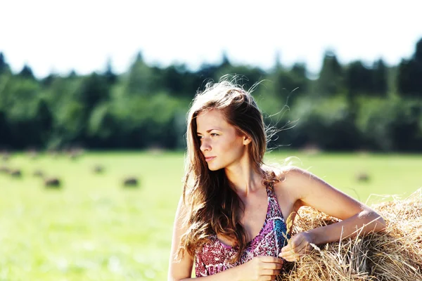 Девушка рядом с стопкой сена — стоковое фото