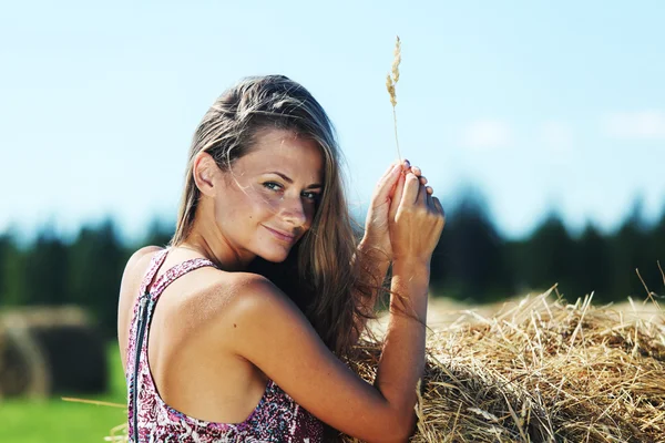 Girl next to a stack of hay — Stock Photo, Image