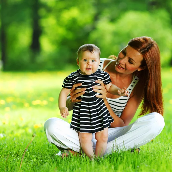 Mother and daughter on the green grass — Stock Photo, Image