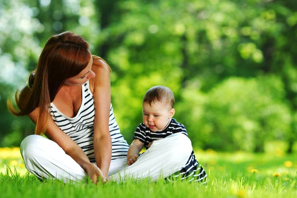 Mother and daughter on the green grass — Stock Photo, Image
