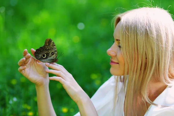 Femme jouant avec un papillon — Photo