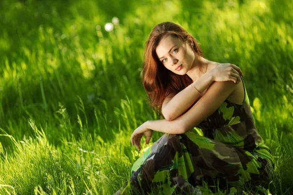 Brunette assise sur herbe verte — Photo