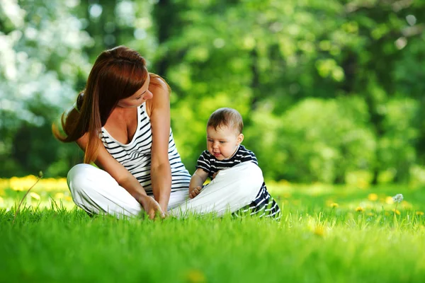 母亲和女儿在绿色草地上 图库图片