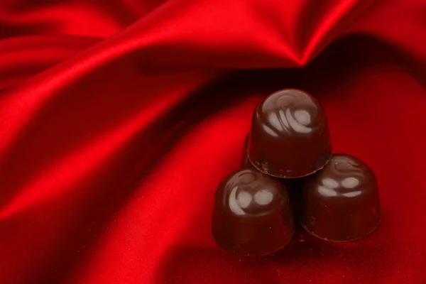 stock image Chocolate candy on red satin