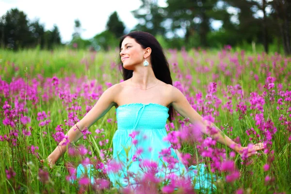 Žena na poli růžový květ — Stock fotografie