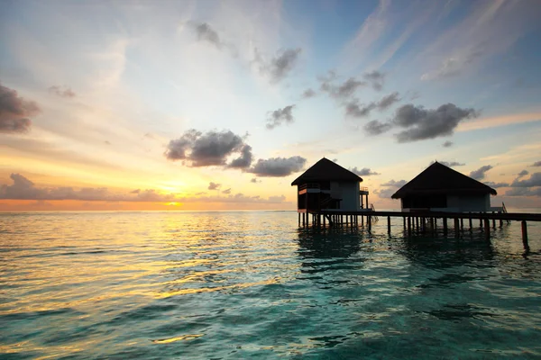 Мальдівські будинки на сході сонця — стокове фото