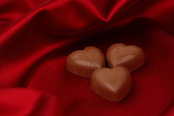 stock image Candy hearts on red satin