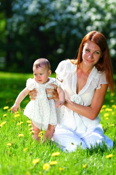 Mãe e filha na grama verde — Fotografia de Stock