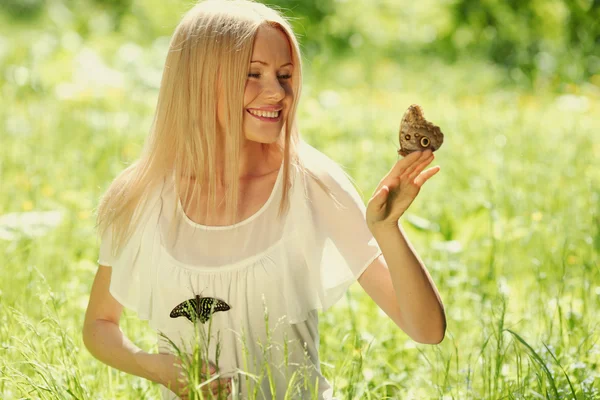 Woman playing with a butterfly — Stock Photo, Image