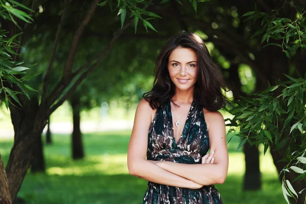 Meisje op een achtergrond van groene bomen — Stockfoto